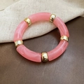 Detail view of pink marble resin tube beads and gold metal spacers on an elastic bracelet - Pink (Marble Texture)