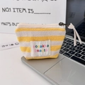 Detail view of yellow striped knit pouch for makeup and coins on a laptop keyboard - 1.5cm Striped Yellow