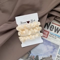 Three-piece set of cream satin scrunchies displayed on a white Sweet Girl card - Cream