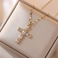 Detail of a gold cross pendant necklace with clear oval cubic zirconia in a jewelry box - Gold Cross Pendant Necklace / Gold/White Zirconia
