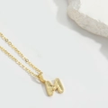 Minimalist golden necklace featuring an M-shaped pendant with honeycomb texture detail - M