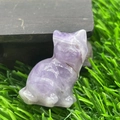 Hand-carved purple amethyst cat statue figurine on natural wood and grass background - Purple Crystal