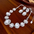 Silver-toned jewelry set with large oval clear crystals on a textured wooden background - Oval Stud Earrings Necklace Set