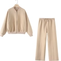 Détail de la veste aviateur beige zippée et du pantalon droit sur un cintre en bois - S / Haut Et Bas / Kaki