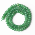 Vista macro de cuentas redondas de piedra verde con textura de jade natural y brillo - Jade Teñido Verde Ábaco