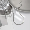 Sleek silver flat snake bone chain necklace in titanium steel on minimalist background - Steel