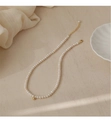 Detail of natural pearl necklace featuring a gold bead clasp on elegant stone surface - Natural Pearl Gold Ball Necklace