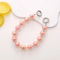Detail view of colorful acrylic beads and silver spring rings for mobile chain - Orange
