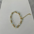 Detail view of 14K gold plated bracelet with square zircon and evil eye enamel charms - White