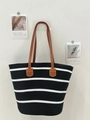 Black and white striped woven tote bag with brown leather handles on a white wall - Black White Wide Stripe