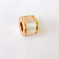 Macro shot of 18k gold rose clover cylinder pendant with white inlay and carved details - B.zero1 Style Cylinder*Gold