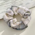 Plaid scrunchie in lemon and grey tones on a vintage magazine for hair styling - JK Lemon Sea Salt
