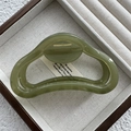 Detail of a green translucent resin hair claw clip with a hollow ring design and gold spring - Fruit Green