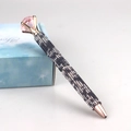 Close-up of luxury rose gold ballpoint pen with pink crystal and blue rhinestones - Cow Print