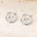 Détail macro de boucles d'oreilles créoles argentées avec texture rayonnante sur pierre - Couleur Acier Texture Radiante 18mm (KE115683-GC)