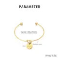 Detalle del brazalete de acero bañado en oro 18K con dije de corazón grabado Love - Dorado