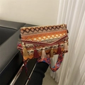 Detailansicht der Boho-Umhängetasche mit geometrischem Webmuster und bunten Quasten - Orange
