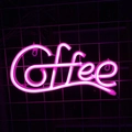 Pink neon 'Coffee' sign glowing on a dark metal grid wall for bar or cafe decor - Pink