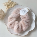 Soft faux rabbit fur scrunchie in pale pink with a fluffy texture for winter styling - Beige