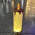 Detail view of transparent LED candle lamp with gold glitter and metallic base - Gold Base
