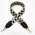 Detail of adjustable bag strap with black and beige arrow pattern and gold metal hooks - Rice Black + Black Leather
