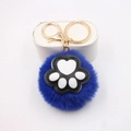 Detail van blauwe pluche kattenpoot sleutelhanger met gouden metalen ring erop - Kattenklauw Goud Sleutelhanger / Koningsblauw
