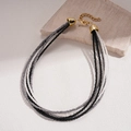 Dettaglio della collana bohémien a strati con perle di vetro nere e argento e chiusura dorata - Collana-Bianco-Nero
