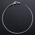 Elegante silberne Schlangenkette mit Karabinerverschluss und Perlenanhänger auf Schwarz - Armband / Weißgold