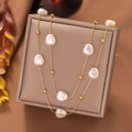 Detailed macro view of double-layer gold chain necklace with baroque pearls and beads - 3D Pearl Necklace - Gold