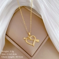 Detalle del collar de corazón y flecha en oro con cristales sobre seda blanca - Estilo de Corazón y Flecha (B509) / Dorado