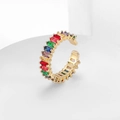 Detailed macro view of gold adjustable ring featuring a vibrant row of rainbow baguette zircons - Colorful