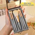 Portable 5-piece makeup brush set in sky blue mirrored storage box held by hand - Haze Blue 5-piece Brush Set + Lens Case