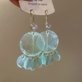Close-up of light green translucent round shell tassel earrings with purple zircon accent - Ear Buckles - Green