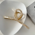 Macro shot of a 13cm marble texture hair claw clip with golden metal spring and cross design - Apricot