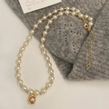 Detail of elegant pearl necklace with gold pea pendant on grey knit sweater background - Gold Pea Pearl Necklace