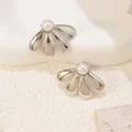 Elegant silver titanium flower stud earrings with central pearl on a stone display - Pearl Flower