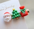 Macro detail of Christmas resin hair clips with Santa and tree motifs on white card - Style 13 Christmas Hair Clip