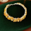 Macro detail of teardrop and round yellow zircon bracelet on green velvet background - Yellow