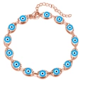 Macro detail of rose gold evil eye bracelet with blue charms and lobster clasp - Rose Gold Light Blue