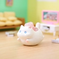 Close-up of a white resin cat figurine with a pink crystal stone on a miniature floor - 1244-1 White Cat Ornament