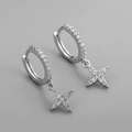Macro de boucles d'oreilles étoiles en argent avec zircons brillants sur fond gris - Créoles Étoile à Quatre Branches Micro-Pavé Zircon - Argent