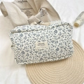Top-down view of a blue floral quilted cotton makeup bag with high-quality zipper detail - Blue Floral / Blue Floral Large / Large