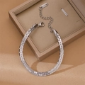 Bracciale a catena cubana d'argento lucido su sfondo satinato con scatola regalo - Stile Minimalista a Catena Piatta / Argento