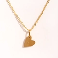 Gros plan du pendentif cœur doré avec gravure de la lettre N sur chaîne en acier - Lettre N