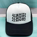 Detail der schwarz-weißen Trucker-Kappe mit gewelltem Alright-Druck und Netzrücken - Einheitsgröße / Schwarz