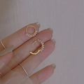 Minimalist gold hoop earrings with small white pearls held between fingers for size - Gold