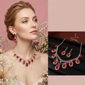 Elegante set di gioielli con pendenti in rubino e nappe di diamanti su sfondo nero - Set Oro Rosso