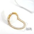 Detailed close-up of 18K gold tennis bracelet with zircon stones on decorative stone - Gold / Stainless Steel + Rectangular Zirconia
