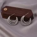 Modern triple-layered silver hoop earrings with textured wavy surface on wooden stand - E-060---Platinum