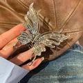 Silver liquid metal butterfly hair claw with sleek flowing texture on denim background - Liquid Butterfly / Silver